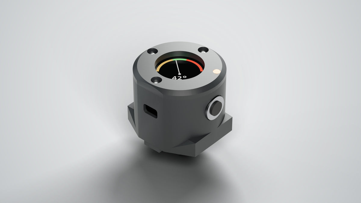 Wheelie Coach handlebar unit, charcoal, three-quarter view: recessed pitch gauge, IP67 side button, USB-C port, GoPro-style mounting foot (render of the Rev 2.1 design)